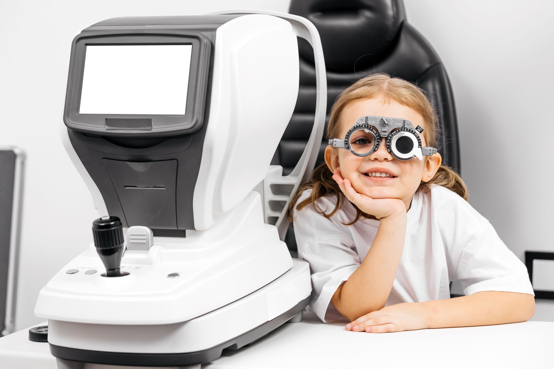 A little girl wearing glasses undergoes vision diagnostics in an ophthalmologist's office. An example of modern methods for diagnosing and treating children's vision.